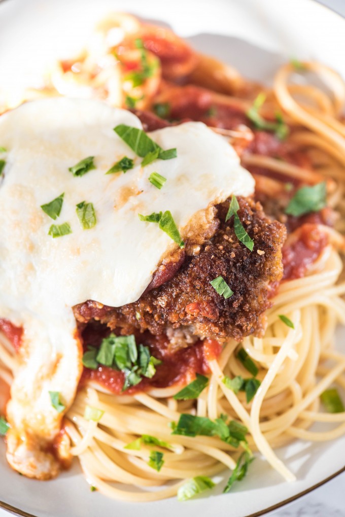 close up shot of chicken parmesan with spaghetti