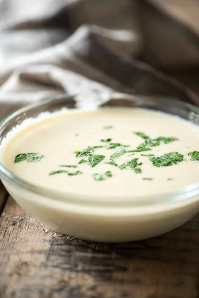 homemade alfredo sauce in glass bowl on wood table
