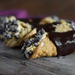Pumpkin cannolis covered in chocolate on a cutting board