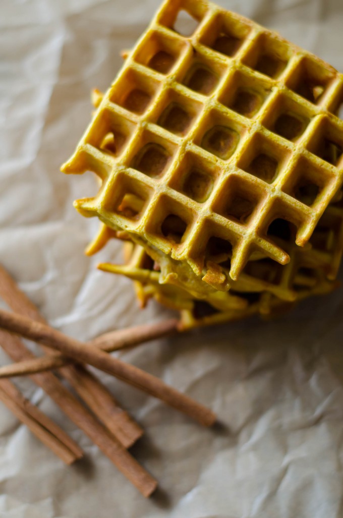 Top of a stack of pumpkin waffles with cinnamon sticks