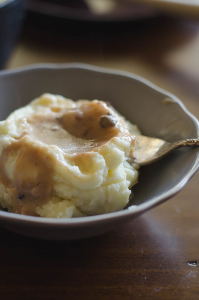 Scoop of whipped potatoes topped with gravy in a gray bowl