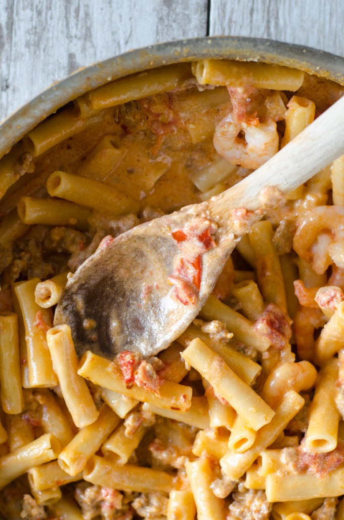 one pot pasta in a pan with a wooden spoon