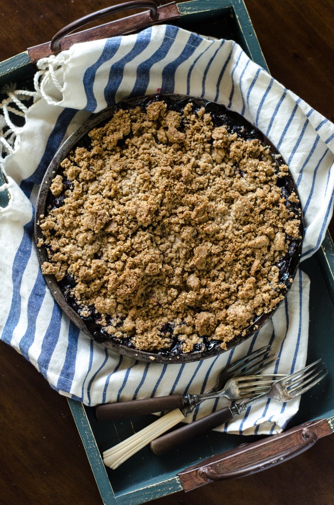 Easy blueberry crisp with fresh blueberries on a blue and white napkin