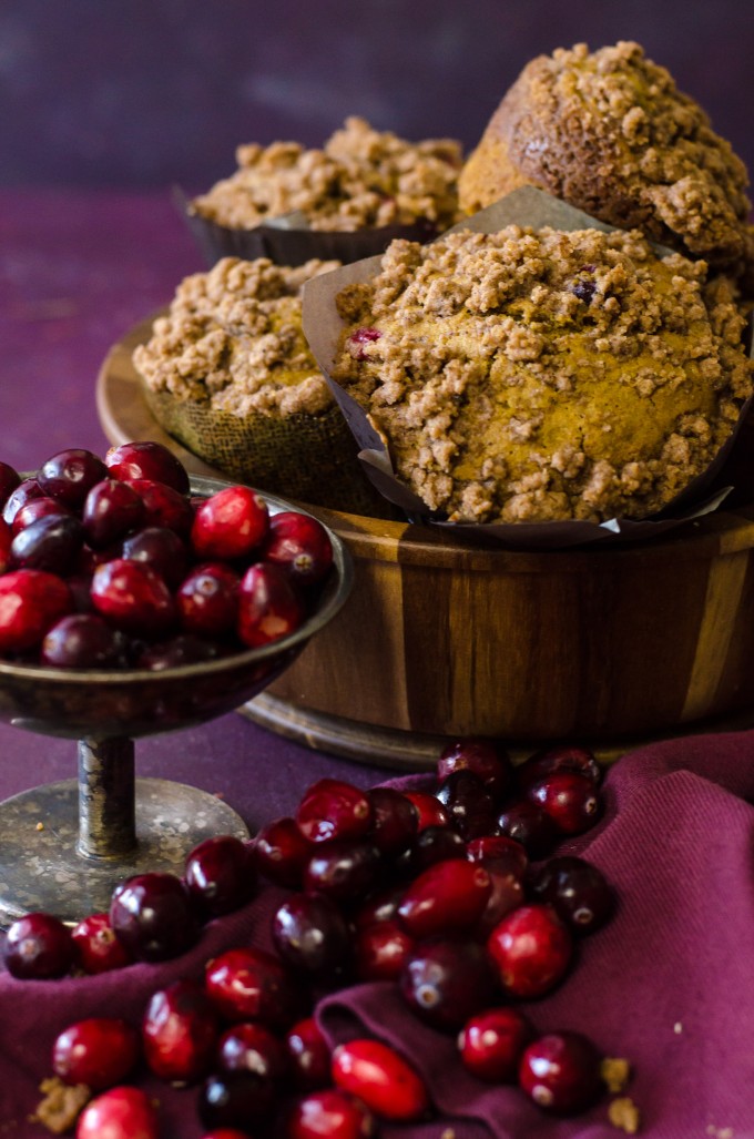 A wooden bowl full of pumpkin cranberry muffins