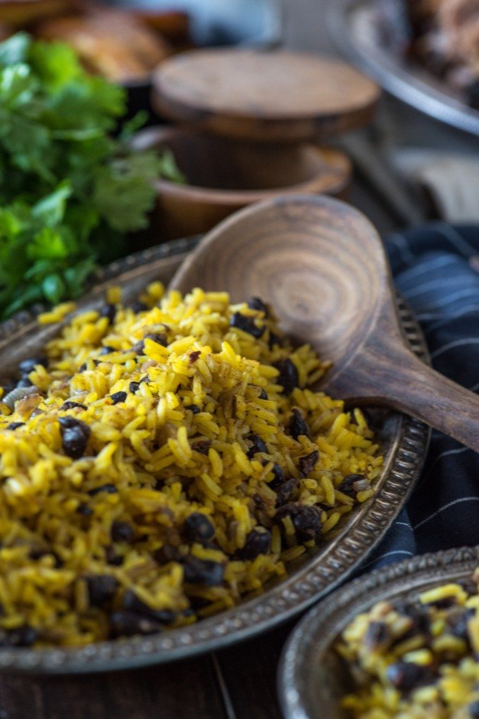 Yellow Rice and Beans in a bowl with a wooden spoon
