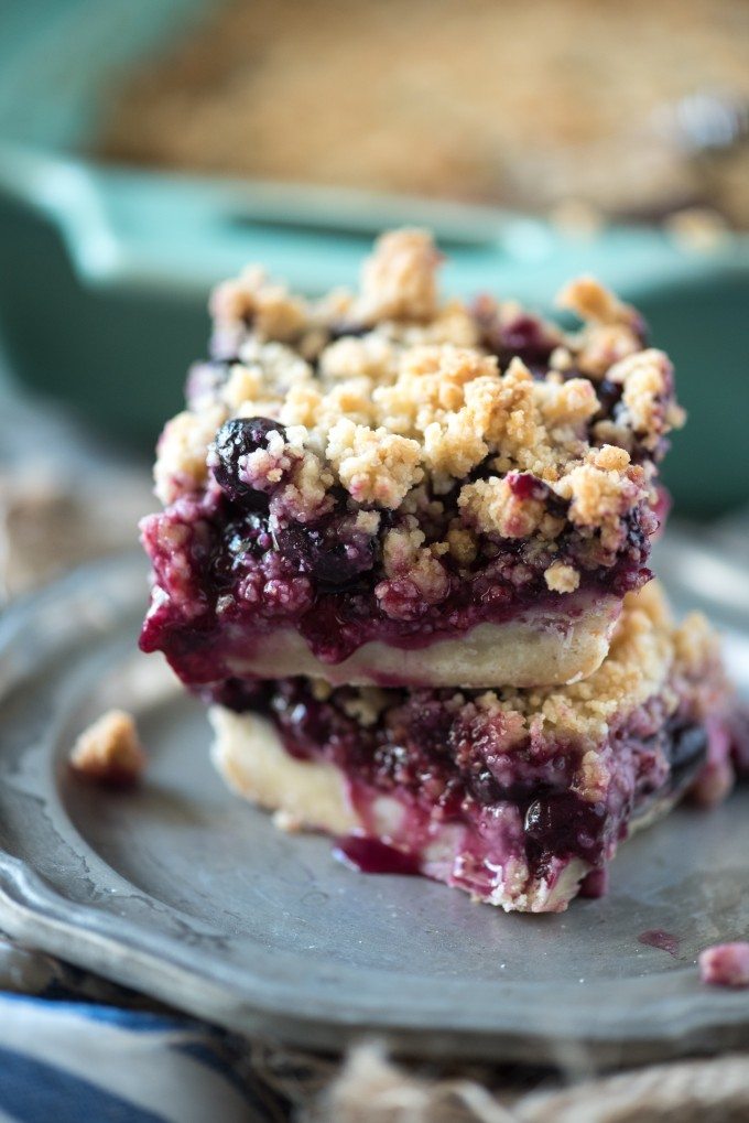 close up of blueberry crumb bars stacked on a plate