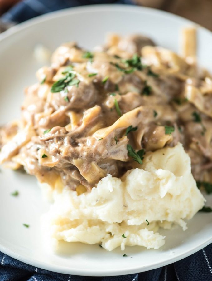 This Amish Beef and Noodles recipe can be made in a slow cooker or an Instant Pot. Served over mashed potatoes, it's an easy and loved dinner recipe!