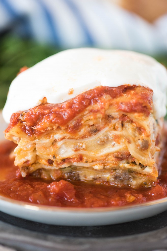 slice of easy lasagna recipe on white plate topped with mozzarella 