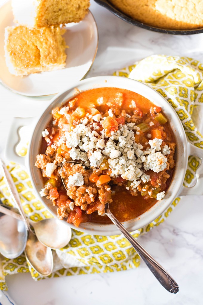 Buffalo Chicken Chili on Mable in white bowl with honey cornbread