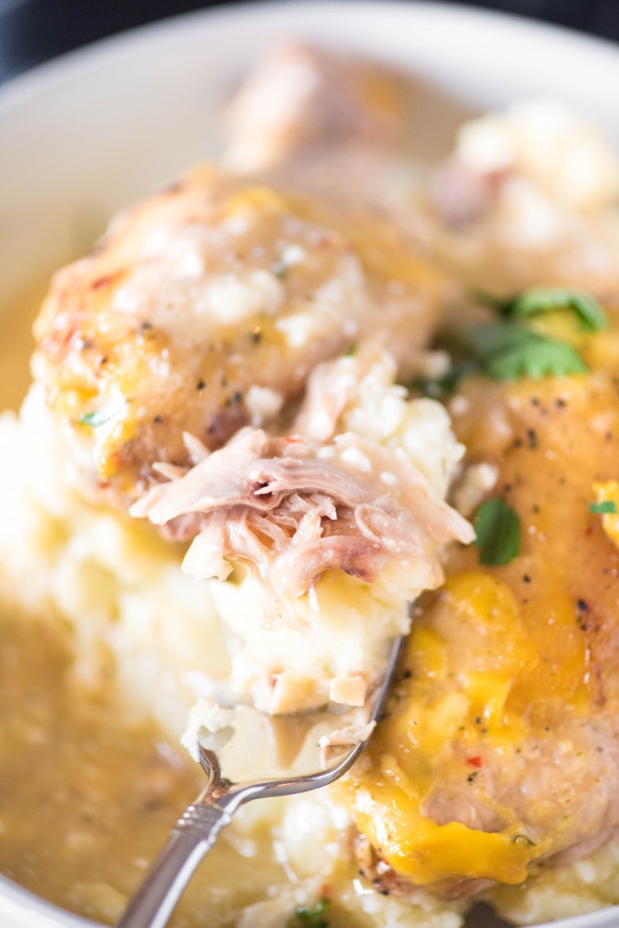 Tender chicken cooked in crockpot with creamy sauce over mashed potatoes