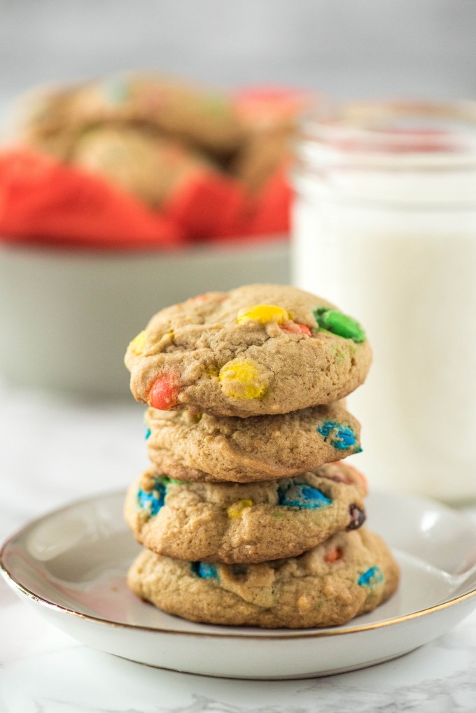Stack of soft M&M cookies with milk