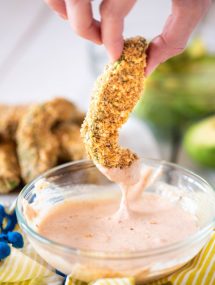 Breaded avocado fries dipped in sauce.