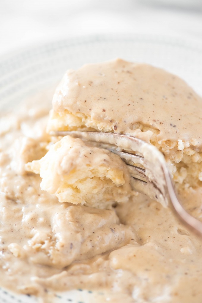 a fork cutting into homemade biscuits and gravy