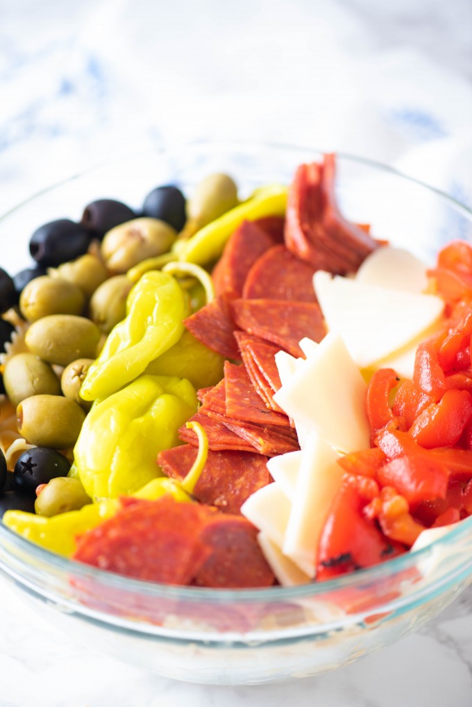 Simple antipasto pasta salad ingredients lined up in a bowl