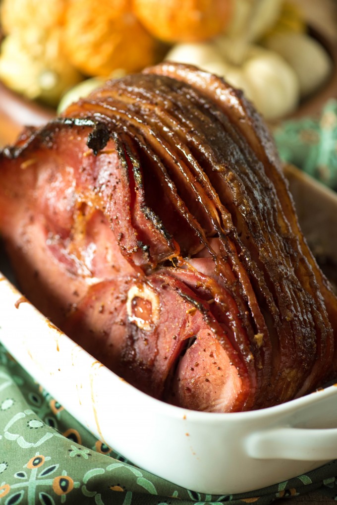 Brown sugar glazed ham in a white baking dish as thanksgiving recipes