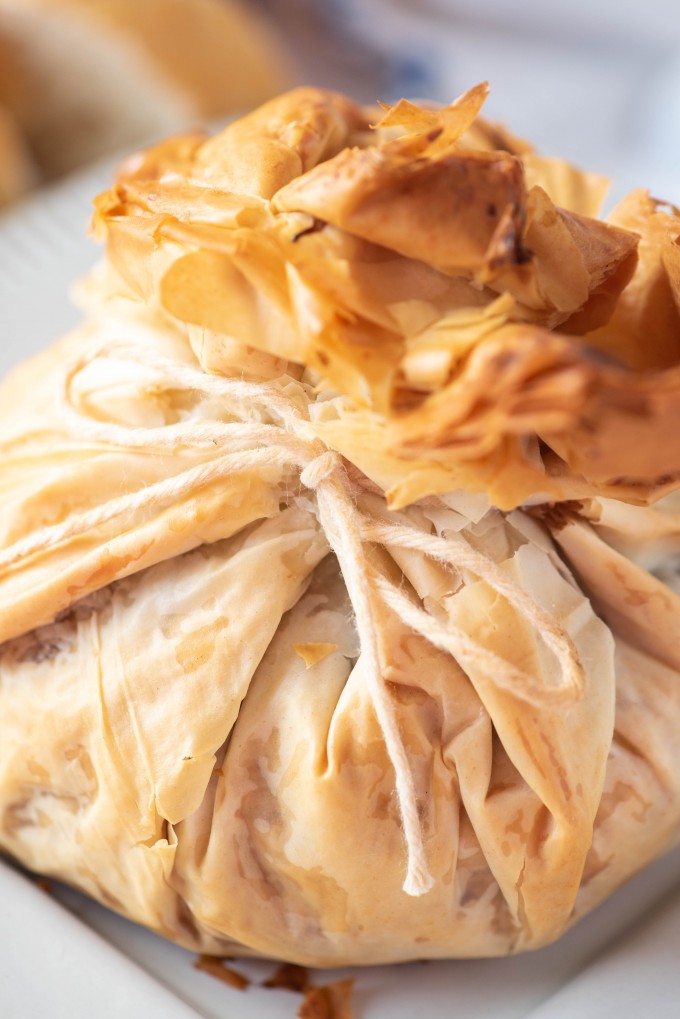 Baked phyllo dough wrapped around brie cheese, tied with kitchen twine