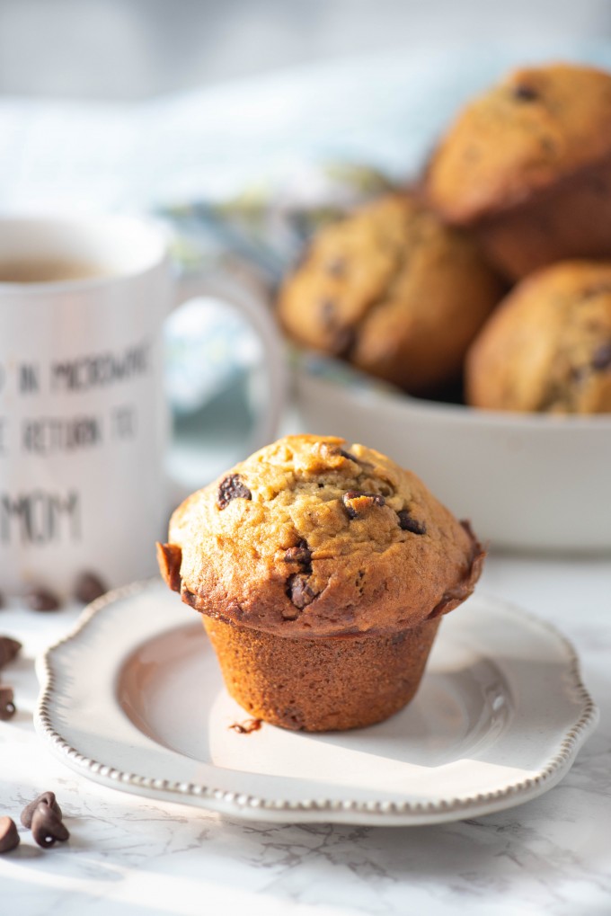 A moist banana chocolate chip muffin on a plate