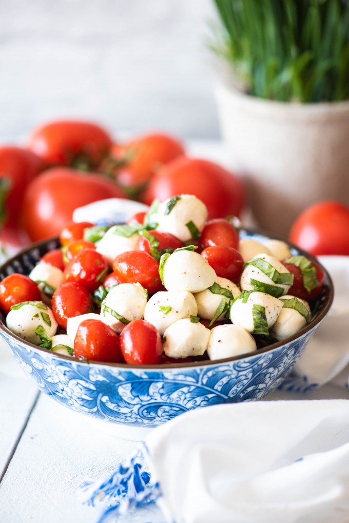 Fresh caprese salad in a blue bowl with tomatoes