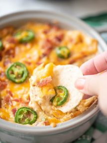 Close up of chip dipping into jalapeno popper dip