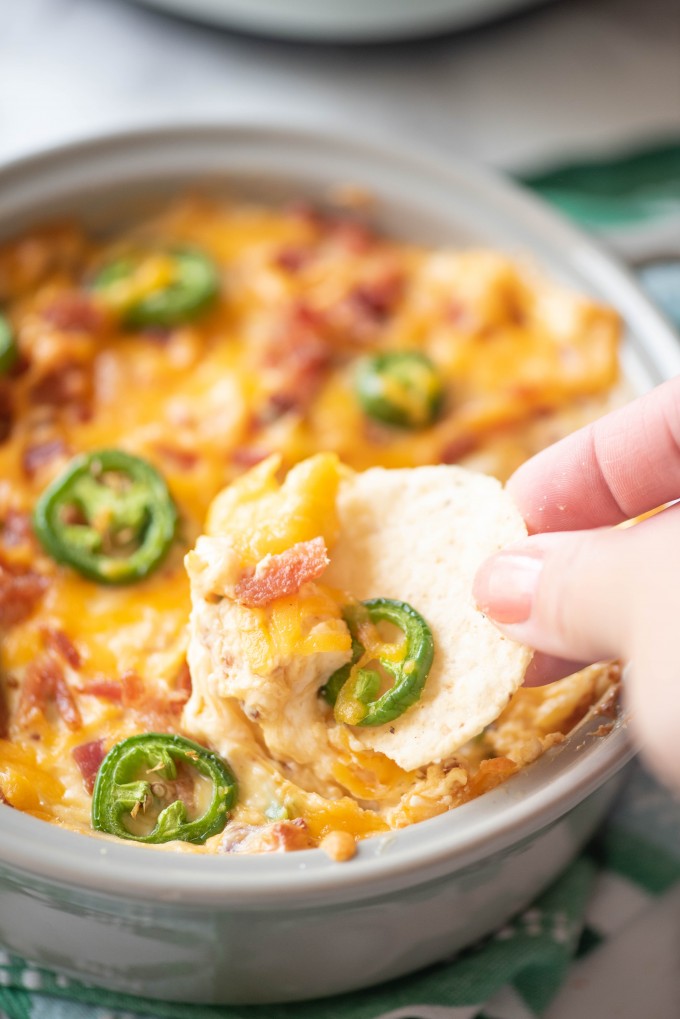 Close up of chip dipping into jalapeno popper dip