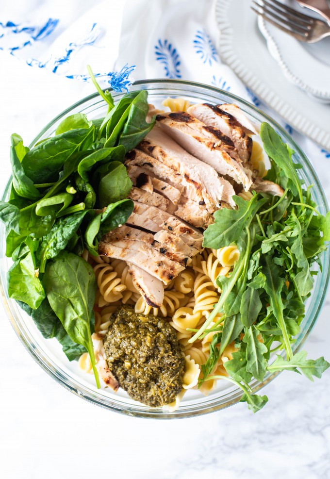 Ingredients of basil pesto pasta in a glass bowl