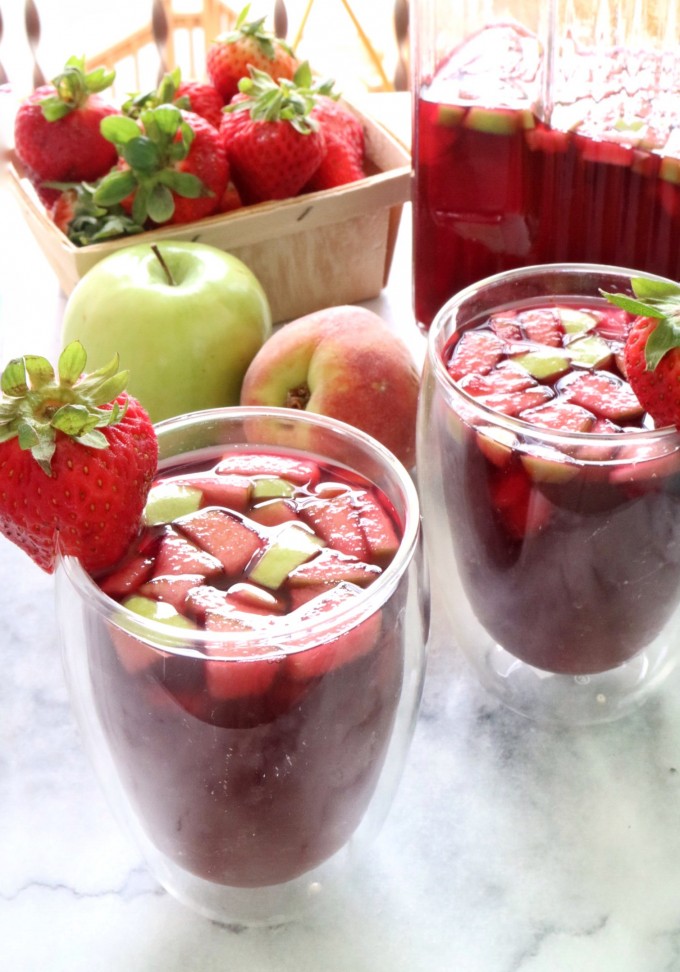 Two glasses of blueberry tea sangria with apples