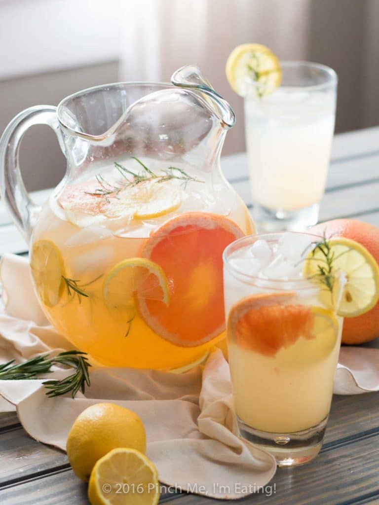 A glass and pitcher of grapefruit lemonade