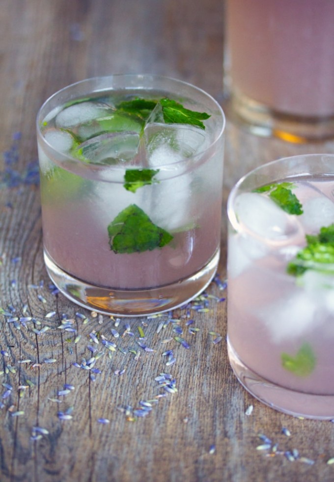 Two glasses of lavender lemonade mojitos with lavender buds