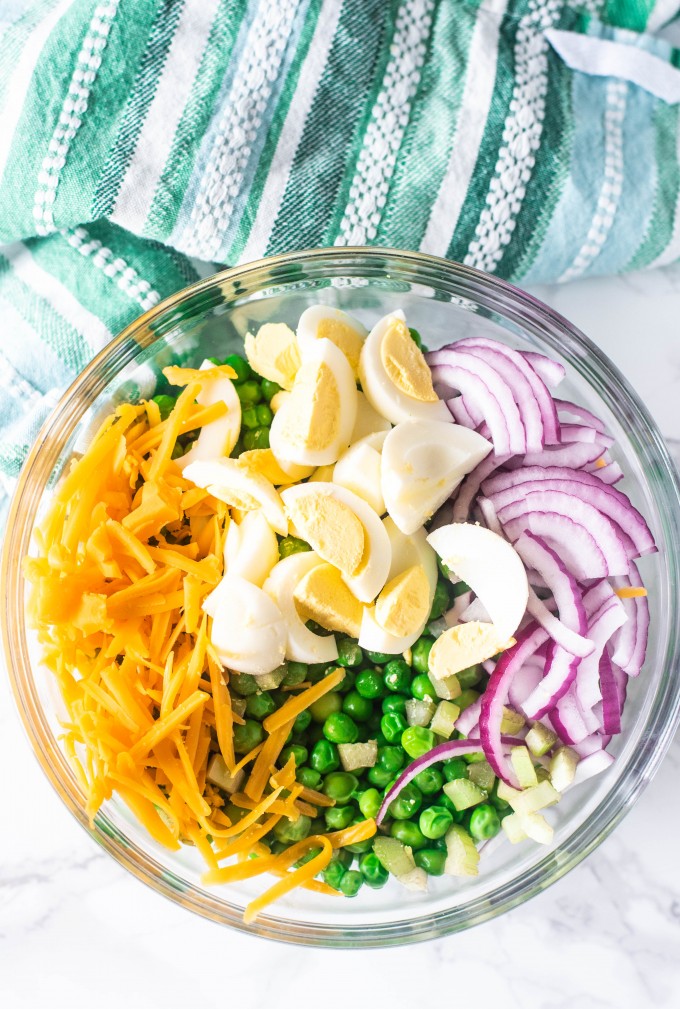 Pea salad with red onion, cheddar cheese and hard boiled eggs