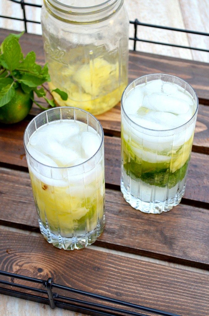 Two pineapple mojitos on a wood tray