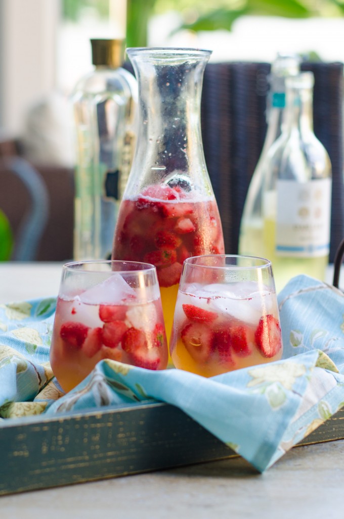 Two glasses and a pitcher or summer sunset sangria on a tray