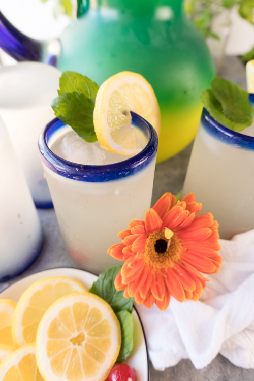 A glass of mint julep with an orange flower