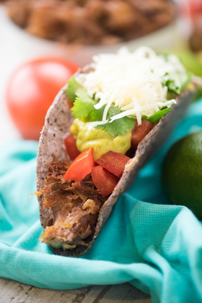Instant pot carnitas in a taco shell on a blue napkin