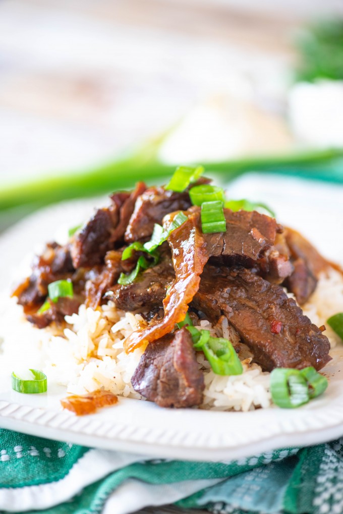 Mongolian beef over white rice on a white plate