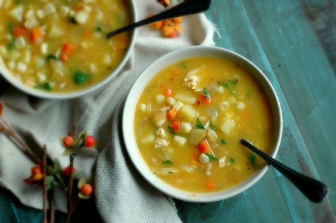 Two bowls of pumpkin corn chowder in white bowls