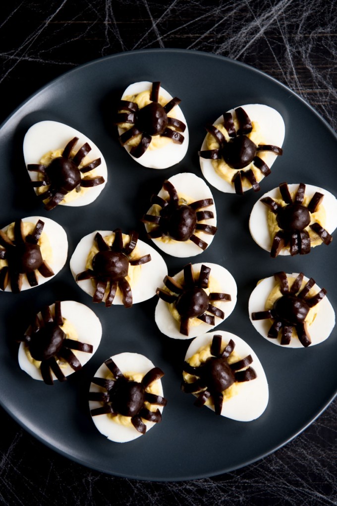 Spider deviled eggs on a black tray