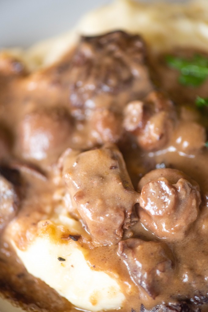 Close up of instant pot beef tips over mashed potatoes