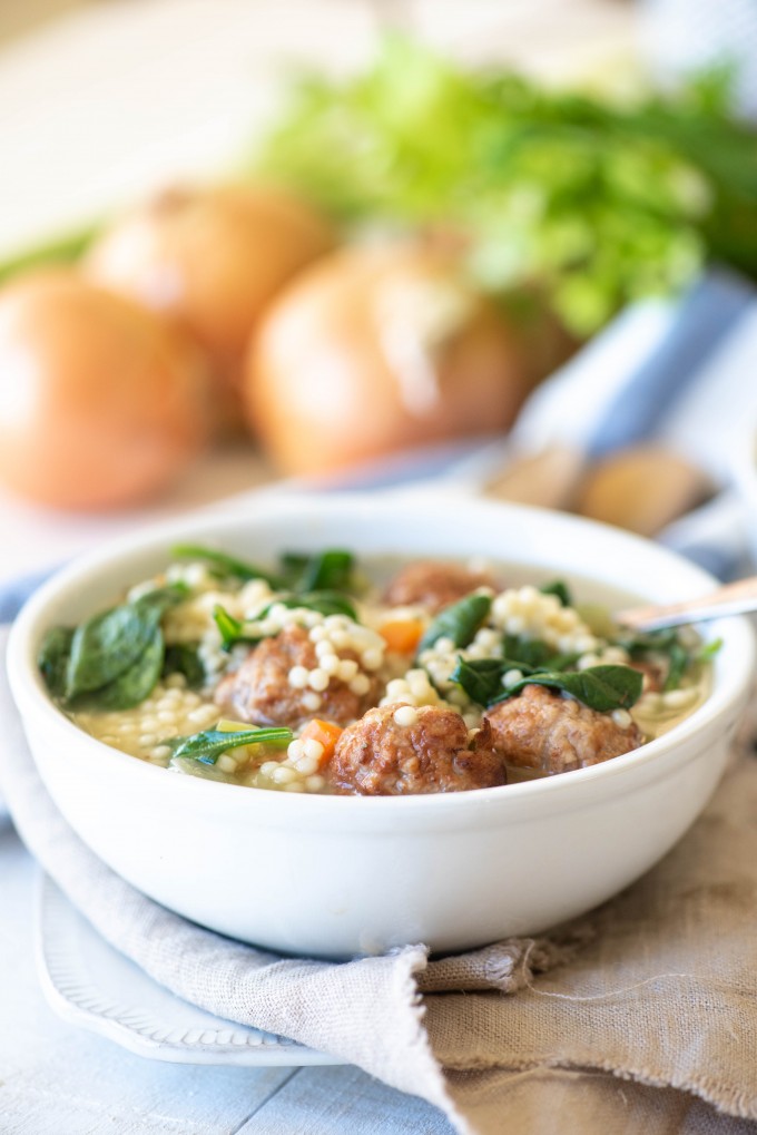 Instant Pot italian wedding soup in a white bowl with a white and blue napkin