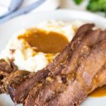 Best instant pot brisket on a white plate with mashed potatoes