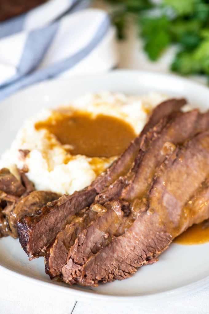 Best instant pot brisket on a white plate with mashed potatoes