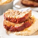 Two slices of instant pot meatloaf on top of mashed potatoes