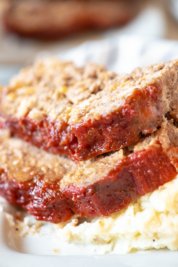 Close up of sliced instant pot meatloaf over mashed potatoes