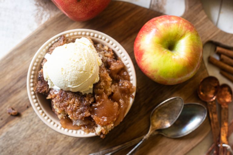 Overhead view of apple dump cake in a bowl topped with ice cream