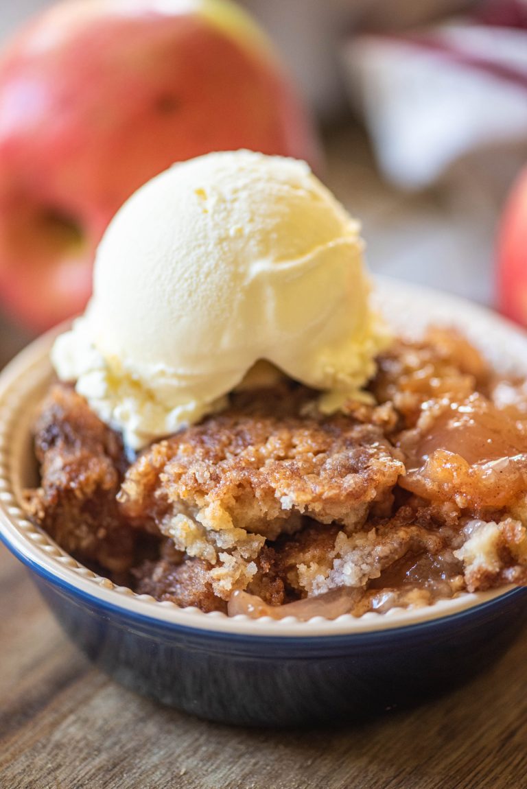 Close up of a bowl of apple dump cake topped with ice cream