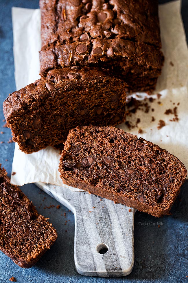 Sliced chocolate zucchini bread on a sheet of parchment paper