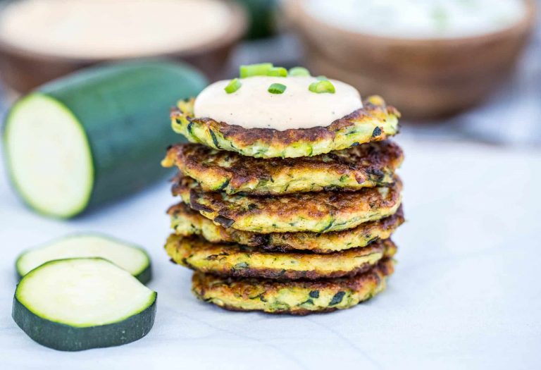 Stack of zucchini fritters topped with sour cream