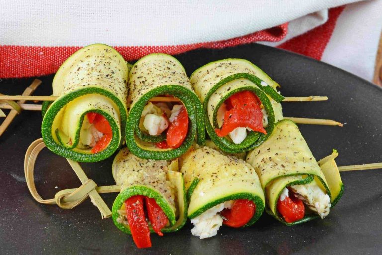 Zucchini goat cheese roll ups stacked on a plate