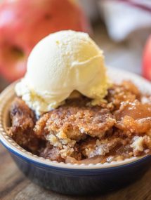 Close up of apple dump cake in a bowl with vanilla ice cream