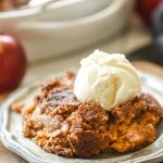 Apple Pumpkin Dump Cake topped with ice cream on a plate