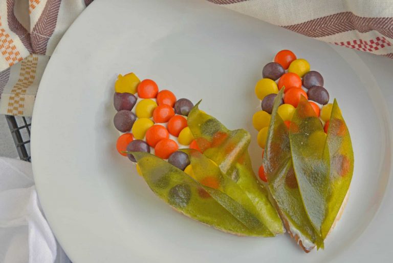 Two thanksgiving corn cookies on a white plate